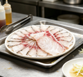 Thinly sliced sashimi-grade fish arranged on a platter (photo 1 of 3)