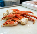 Cooked snow crab legs with vivid red shells on ice (photo 1 of 3)
